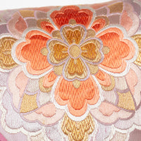 Orange flower design on obi silk with metallic threads, made into cushion.