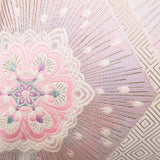 Detail of pink silk obi pillow with silver, cream and pale blue accents.